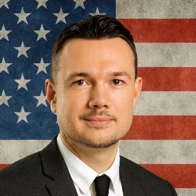 Andrew B. Raupp, with an American flag backdrop